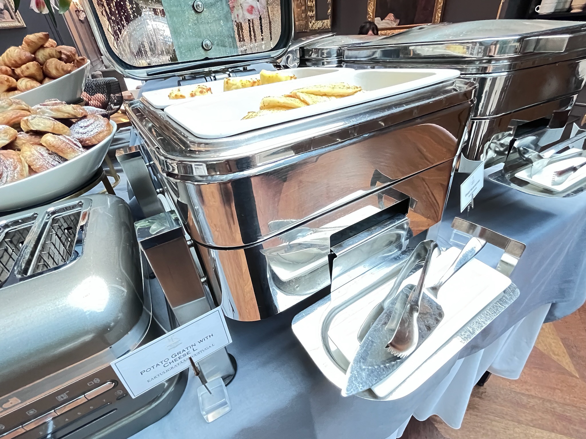ホテル朝食ビュッフェで提供されている、こんがりと焼き色がついた温かいポテトグラタン