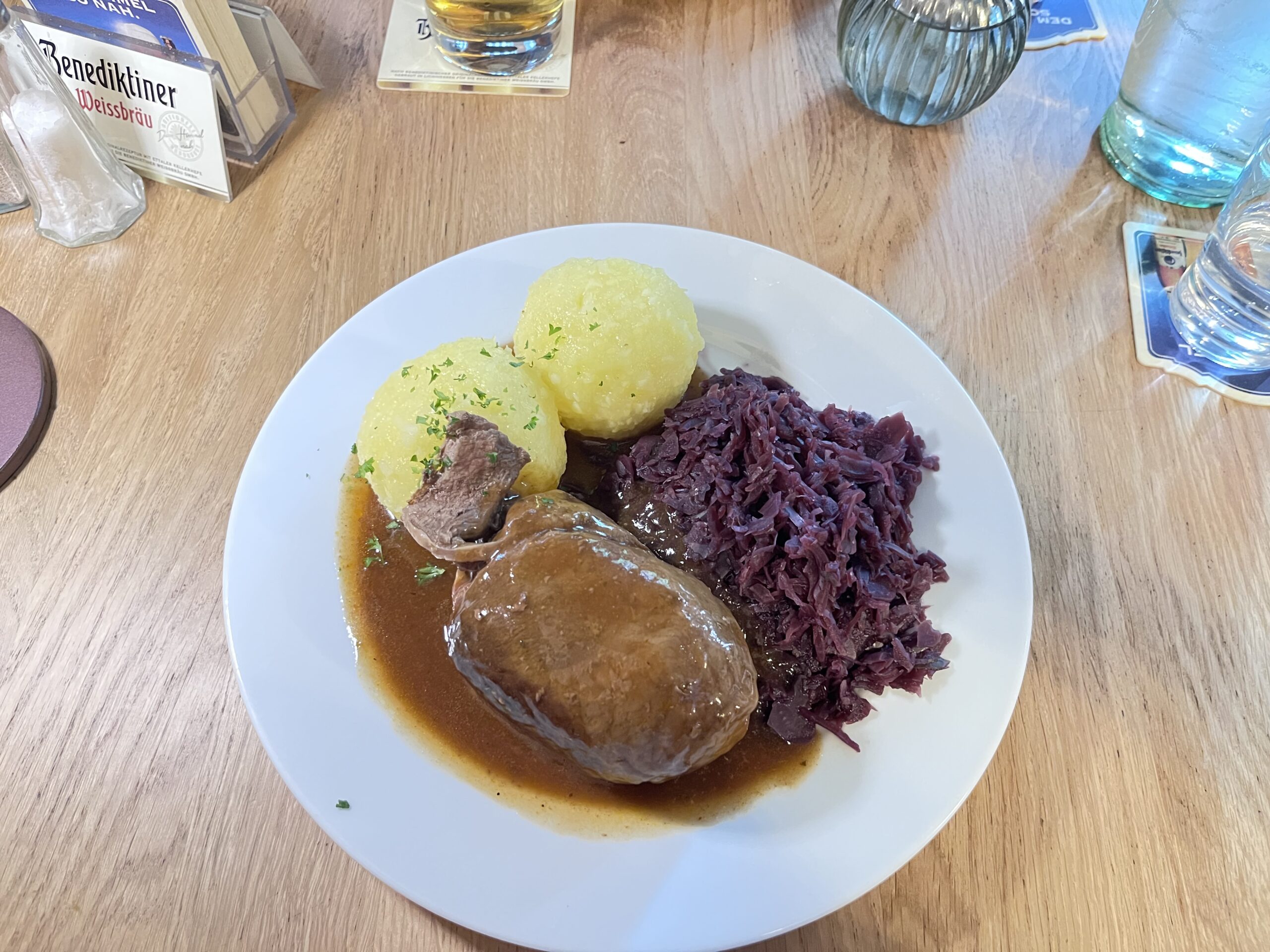 ビールソースがかかったベーコン巻き牛肉と赤キャベツ・ダンプリングのプレート