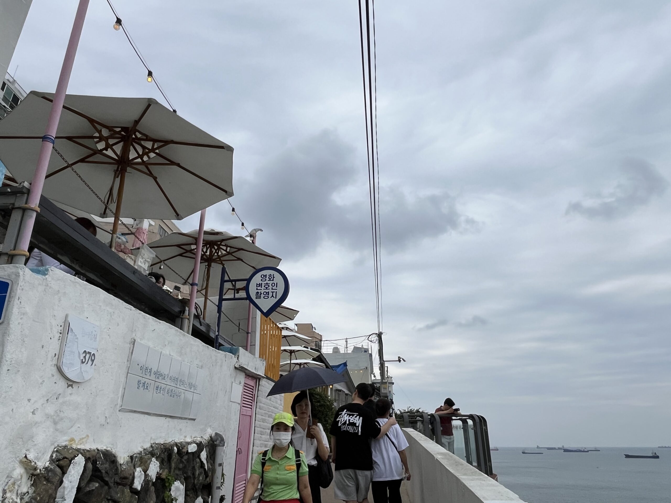 「韓国のサントリーニ島」と呼ばれる白瀬文化村(ヒンヨウル文化村)の看板と海沿いの景色